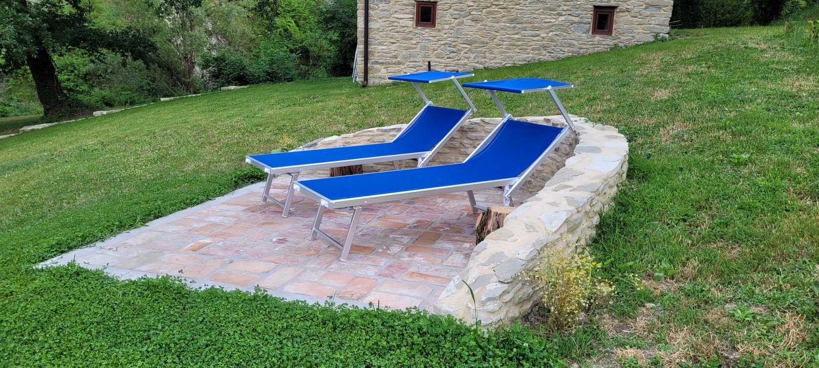 Area lettini con due sdraio nel giardino del casale